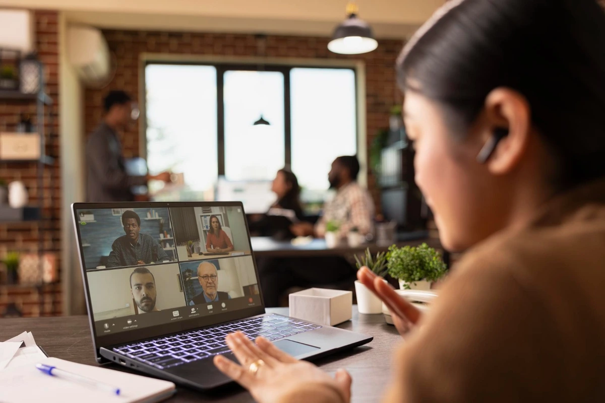 Pessoa em videochamada com a equipe da Siteware, num escritório