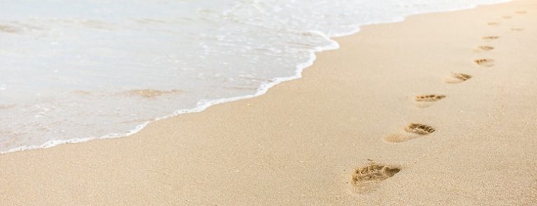 pegadas na praia simbolizando como implementar KPIs na sua empresa